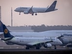 A Lufthansa aircraft lands while two others wait at an airport.