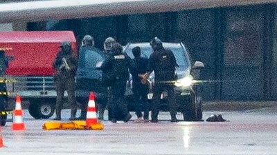 A man is led away by the police outside Germany's Hamburg airport. (AP) A man is led away by the police outside Germany's Hamburg airport. (AP)