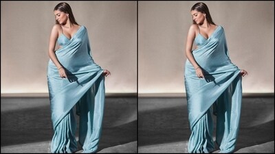 Her saree comes in an enchanting ice blue shade and is crafted from a luxurious silk fabric. She draped it gracefully around her with beautiful cascading pallu from her shoulders. She paired it with a V-neck bralette style blouse. (Instagram/@tarasutaria) Her saree comes in an enchanting ice blue shade and is crafted from a luxurious silk fabric. She draped it gracefully around her with beautiful cascading pallu from her shoulders. She paired it with a V-neck bralette style blouse. (Instagram/@tarasutaria)