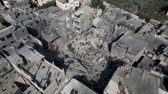Palestinians search for casualties, at the site of Israeli strikes on houses, amid the ongoing conflict between Israel and Palestinian Islamist group Hamas.