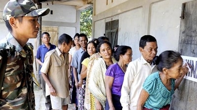 Security personnel look on as voters stand in queue to cast their votes at a polling station. (HT File) Security personnel look on as voters stand in queue to cast their votes at a polling station. (HT File)
