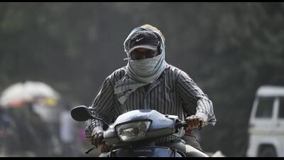 A scooterist wears a mask for protection against pollution. (HT Photo)