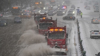 Snow removal vehicles move on a street amid a blizzard in Harbin, Heilongjiang province, China. (Reuters)