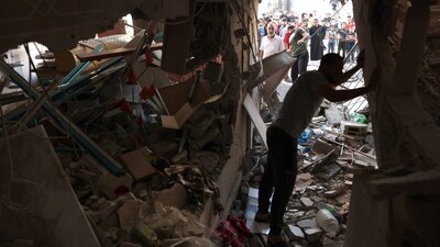 People inspect the rubble of a building in Rafah in the southern Gaza Strip on November 6, 2023, amid the ongoing battles between Israel and the Palestinian group Hamas. (AFP) People inspect the rubble of a building in Rafah in the southern Gaza Strip on November 6, 2023, amid the ongoing battles between Israel and the Palestinian group Hamas. (AFP)