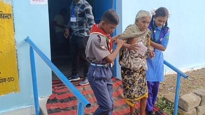 An elderly voter being assisted as she arrives to cast her vote for the 1st phase of Chhattisgarh Assembly elections in Sukma district. (PTI)