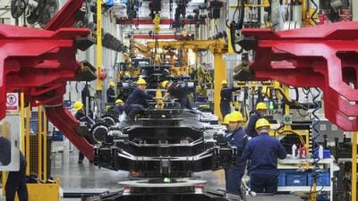 Workers assemble mini excavators in a factory of heavy machinery in Suzhou in eastern China’s Jiangsu province. (AP)