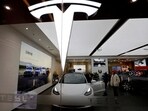 Visitors check a Tesla Model 3 car next to a Model Y displayed at a showroom of the U.S. electric vehicle (EV) maker in Beijing, China.