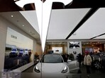 Visitors check a Tesla Model 3 car next to a Model Y displayed at a showroom of the U.S. electric vehicle (EV) maker in Beijing, China. (REUTERS)