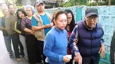 An elderly voter being assisted on his arrival to cast his vote for the Mizoram Assembly elections. (ANI  )