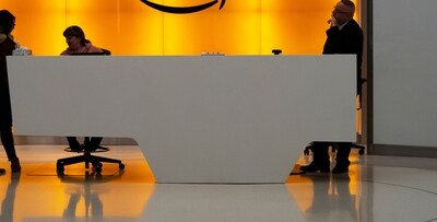 In this Feb. 14, 2019, file photo people stand in the lobby for Amazon offices in New York. Amazon is kicking off its annual security-focused cloud computing conference on Tuesday amid a slowdown in its profitable cloud business Amazon Web Services, or AWS. (AP Photo/Mark Lennihan, File)