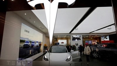 Visitors check a Tesla Model 3 car next to a Model Y displayed at a showroom of the U.S. electric vehicle (EV) maker in Beijing, China. (REUTERS)
