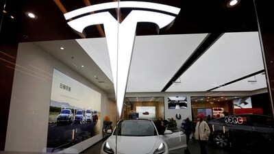 Visitors check a Tesla Model 3 car next to a Model Y displayed at a showroom of the U.S. electric vehicle (EV) maker in Beijing, China. (REUTERS)