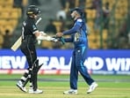 Chamika Karunaratne (R) greets New Zealand's Tom Latham after their win at the end of the 2023 ICC Men's Cricket World Cup one-day international (ODI) match 