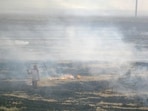 Farmers burn paddy stubble at a village in Kapurthala on Wednesday. (PTI)