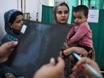In this picture taken on November 7, a doctor (out of frame) examines the X-ray of a child with breathing difficulties at the emergency ward of the government-run Chacha Nehru Bal Chikitsalaya children hospital in New Delhi. 