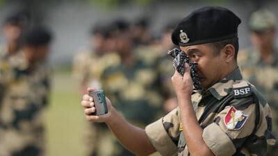 A Border Security Force (BSF) soldier wipes his tears as he takes a video of a wreath-laying ceremony for his colleague Lal Fam Kima in Jammu (AP) A Border Security Force (BSF) soldier wipes his tears as he takes a video of a wreath-laying ceremony for his colleague Lal Fam Kima in Jammu (AP)
