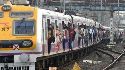 A crowded local passenger train approaches a platform in Mumbai on July 5, 2019. (Photo by Punit PARANJPE / AFP) (AFP)