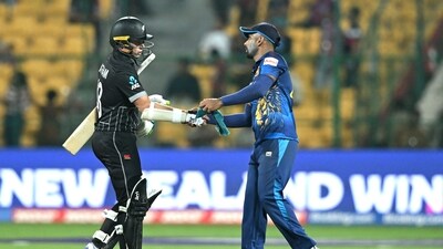 Chamika Karunaratne (R) greets New Zealand's Tom Latham after their win at the end of the 2023 ICC Men's Cricket World Cup one-day international (ODI) match (AFP)