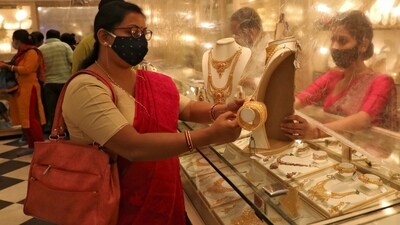 Today Gold, silver prices: Woman looks at a gold necklace at a jewellery showroom. (REUTERS)
