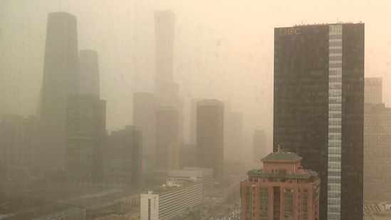 A view of the central business district shot through a glass window during a dust storm in Beijing. (Borg Wong / AP)