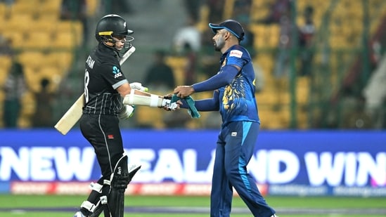 Chamika Karunaratne (R) greets New Zealand's Tom Latham after their win at the end of the 2023 ICC Men's Cricket World Cup one-day international (ODI) match (AFP)