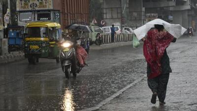 Commuters brave the rain in Amritsar on Friday. (Sameer Sehgal/HT)