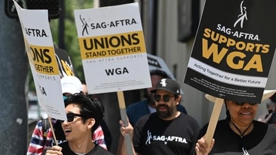 Hollywood writers and their supporters from the SAG AFTRA actors' union walk the picket line outside Warner Bros Studios in Burbank, California. (Photo by Robyn Beck / AFP) (AFP) Hollywood writers and their supporters from the SAG AFTRA actors' union walk the picket line outside Warner Bros Studios in Burbank, California. (Photo by Robyn Beck / AFP) (AFP)
