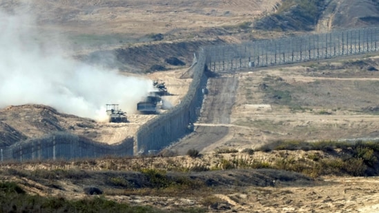 A picture taken from southern Israel near the border with the Gaza Strip shows Israeli army vehicles crossing back into Israel from Gaza