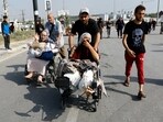 A Palestinian woman, who was injured in an Israeli strike and was staying at Al Shifa hospital, moves southward after fleeing north Gaza as Israeli tanks roll deeper into the enclave.
