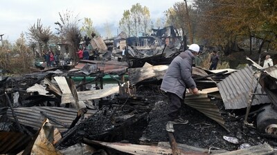 People inspect the charred remains after several houseboats were gutted in Dal Lake due to a massive fire that broke out on one of the houseboats in Srinagar on Saturday. (ANI) People inspect the charred remains after several houseboats were gutted in Dal Lake due to a massive fire that broke out on one of the houseboats in Srinagar on Saturday. (ANI)