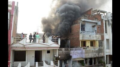 An operation underway to rescue three of a family stuck in a house on fire, in Bahadurganj area of Prayagraj on Saturday morning. (HT)