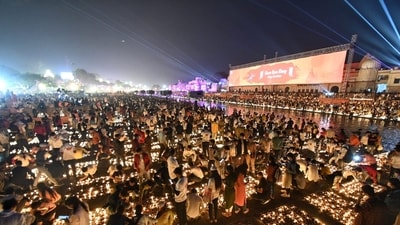 Volunteers light up the diyas at the ghats of the Saryu river in Ayodhya. (Deepak Gupta/Hindustan Times)