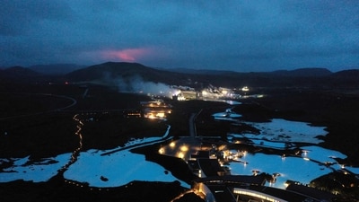 The red shimmer from magma is seen coming out from the erupting Fagradalsfjall volcano behind the tourist landmark Blue Lagoon, near the town of Grindavik on March 20, 2021. (AFP) The red shimmer from magma is seen coming out from the erupting Fagradalsfjall volcano behind the tourist landmark Blue Lagoon, near the town of Grindavik on March 20, 2021. (AFP)