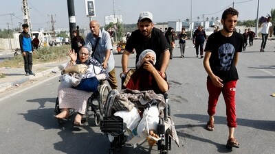 A Palestinian woman, who was injured in an Israeli strike and was staying at Al Shifa hospital, moves southward after fleeing north Gaza as Israeli tanks roll deeper into the enclave. (REUTERS)