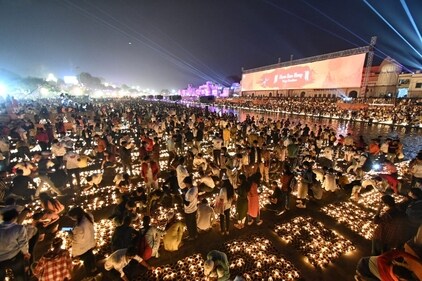 Volunteers light up the diyas at the ghats of Saryu river. (Deepak Gupta/Hindustan Times)