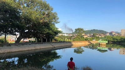 This photo taken on November 7 shows a man watching smoke rising from the direction of a Myanmar military base in Lashio township. (AFP) This photo taken on November 7 shows a man watching smoke rising from the direction of a Myanmar military base in Lashio township. (AFP)