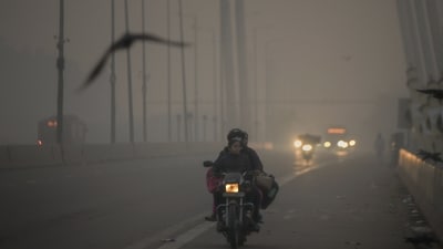 Commuters travel on the Signature Bridge amid low visibility as the air quality again goes down to the 'Poor' category in New Delhi on November 13. (ANI) Commuters travel on the Signature Bridge amid low visibility as the air quality again goes down to the 'Poor' category in New Delhi on November 13. (ANI)
