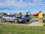 This photo provided by the McKinney Fire Department shows officials at the site of a crash involving a small plane and a vehicle near Aero Country Airport, Saturday, Nov. 11, 2023, in McKinney, Texas. Authorities say a small plane overshot the runway while trying to land at a Texas airport and struck a car that was driving along a nearby road, injuring one person.  (McKinney Fire Department via AP)