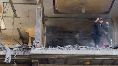 Israel-Hamas War: Palestinians remove debris from a damaged building, in the aftermath of an Israeli strike on a house. (Reuters)