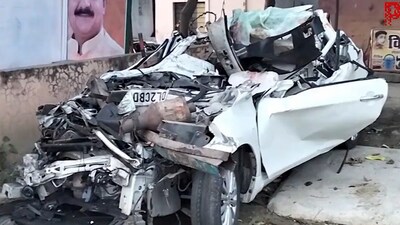 Police used crane to extract the car pressed under the truck. (PTI) Police used crane to extract the car pressed under the truck. (PTI)