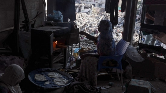 Israel-Hamas War: A Palestinian woman bakes bread in her home destroyed during the Israeli bombardment of Gaza, in Bureij. (AFP)