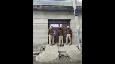 A police team pasting a freezing order outside the house of a drug smuggler in Gandiwind village of Tarn Taran sub-division. (HT Photo)