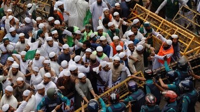 Members of the Islami Andolan Bangladesh, a political party, try to remove barricades as they join in a mass protest march towards the Election Commission, ahead of the election schedule declaration, in Dhaka. (REUTERS)