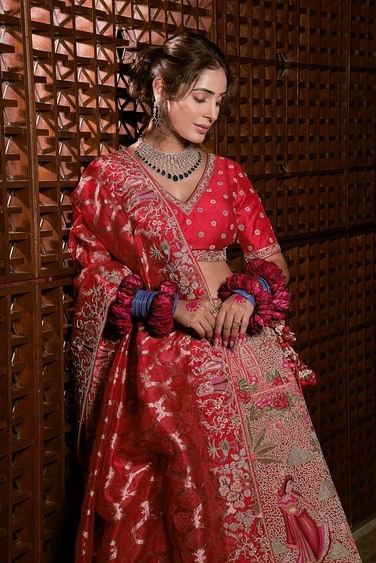 Alankrita Sahai teams her red lehenga with an elaborate tanzanite and diamond neckpiece by Naulakha Jewellers. She completes the look with pink alta, blue glass bangles and red rose kada. Alankrita Sahai teams her red lehenga with an elaborate tanzanite and diamond neckpiece by Naulakha Jewellers. She completes the look with pink alta, blue glass bangles and red rose kada.