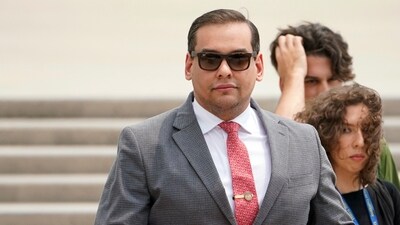 FILE - U.S. Rep. George Santos, R-N.Y., holds a miniature American flag that was presented to him as he departs federal court, June 30, 2023, in Central Islip, N.Y. (AP Photo/John Minchillo, File) (AP) FILE - U.S. Rep. George Santos, R-N.Y., holds a miniature American flag that was presented to him as he departs federal court, June 30, 2023, in Central Islip, N.Y. (AP Photo/John Minchillo, File) (AP)