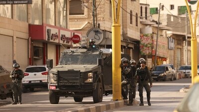 Israeli security forces surround the area of a Palestinian home, believed to belong to one of the gunmen that attacked an Israel checkpoint. (AFP) Israeli security forces surround the area of a Palestinian home, believed to belong to one of the gunmen that attacked an Israel checkpoint. (AFP)