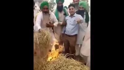 A video grab of farmers holding Punjab PWD sub divisional engineer Hardeep Sagar by the arm and forcing him to torch the paddy residue at Mehma Sarja village in Bathinda district. (HT File) A video grab of farmers holding Punjab PWD sub divisional engineer Hardeep Sagar by the arm and forcing him to torch the paddy residue at Mehma Sarja village in Bathinda district. (HT File)