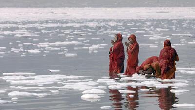 Devotees take a holy dip in the polluted and toxic Yamuna during Chhath Puja in Noida on Friday. (PTI)