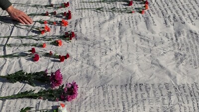 Flowers are left on a list of names of those killed in Palestine as Harvard Law Students participate in the National Day of Action organized by Law Students for a Free Palestine, a coalition of students from 38 law schools around the country, at Harvard University (REUTERS)