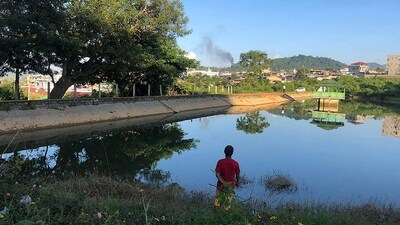This photo taken on November 7 shows a man watching smoke rising from the direction of a Myanmar military base in Lashio township. (AFP)